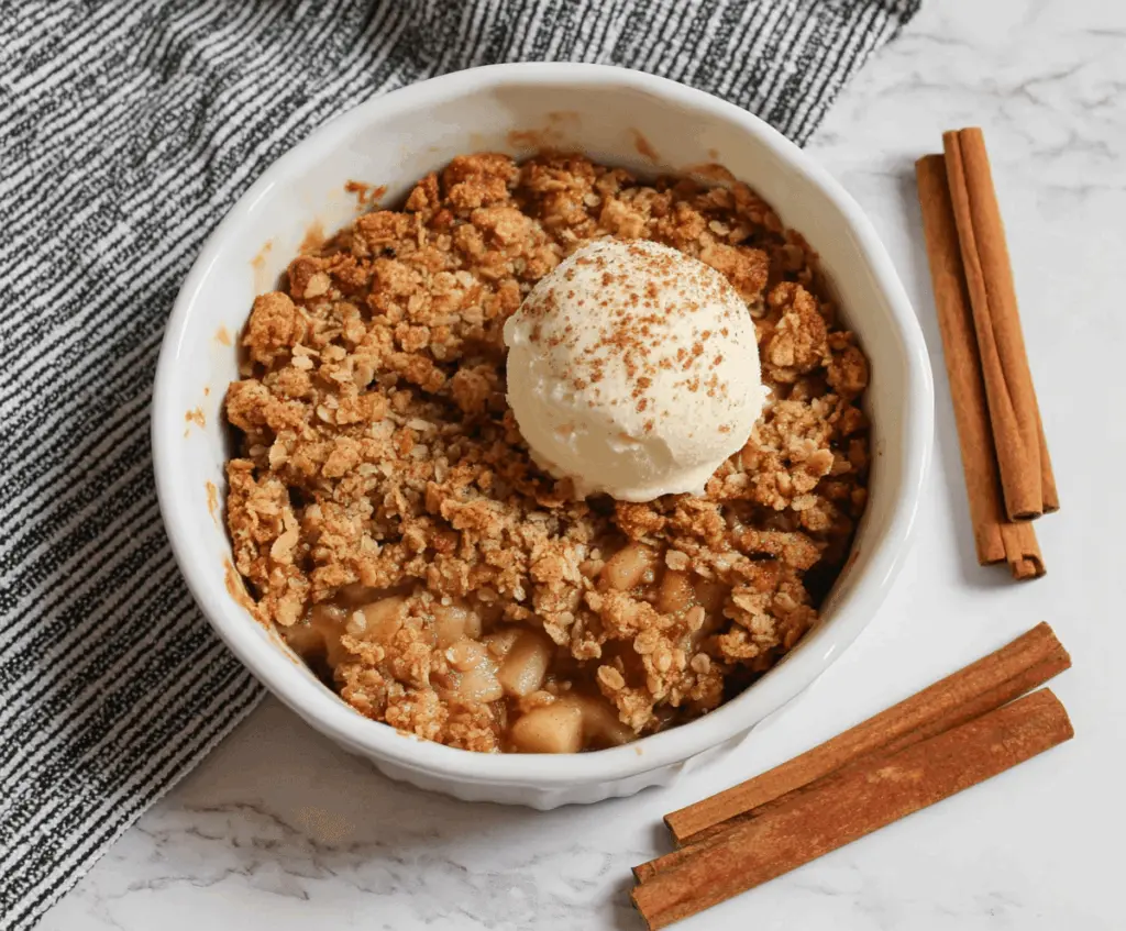 Delicious homemade air fryer apple crisp topped with golden brown crust and fresh apple slices, ready to serve.