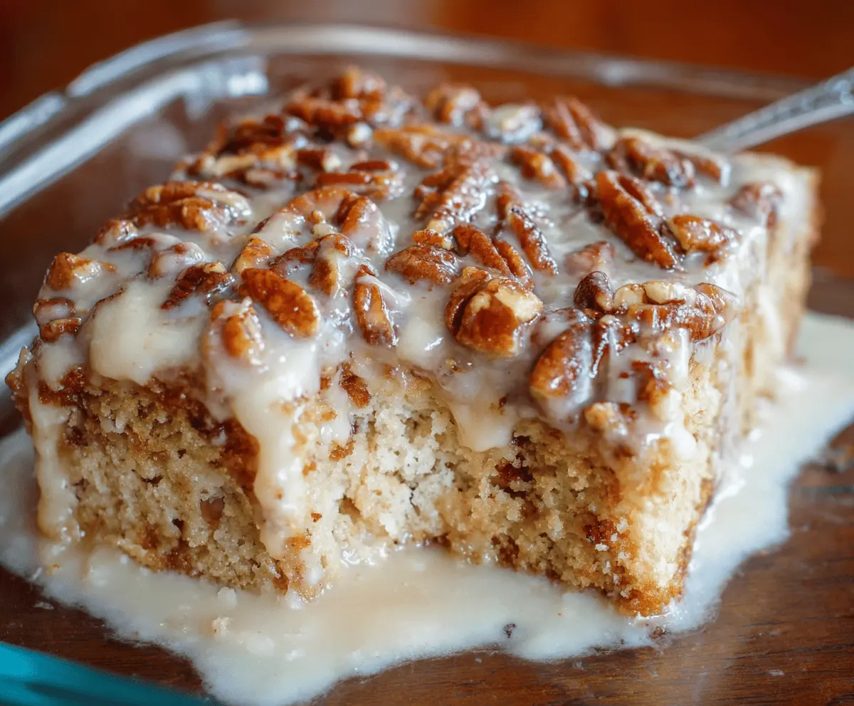 Delicious Butter Pecan Praline Poke Cake topped with caramelized pecans and creamy frosting, perfect for dessert lovers.
