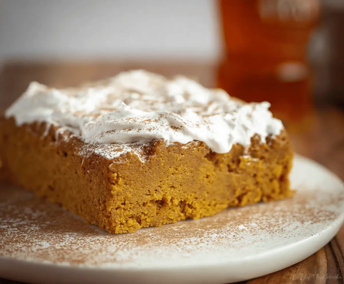 Delicious pumpkin 3-ingredient cake with moist texture, topped with whipped cream and pumpkin seeds, perfect for fall desserts