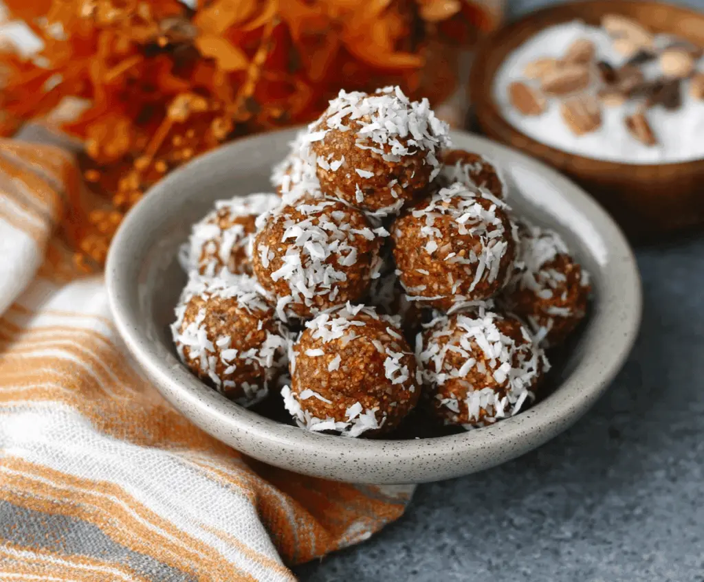 Healthy pumpkin coconut energy balls on a white plate, featuring a blend of pumpkin, coconut, and natural ingredients for a nutritious snack