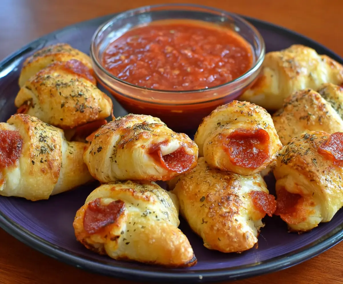 Crescent Pizza Rolls on a plate with melted cheese and pepperoni slices, perfect for snack or appetizer.