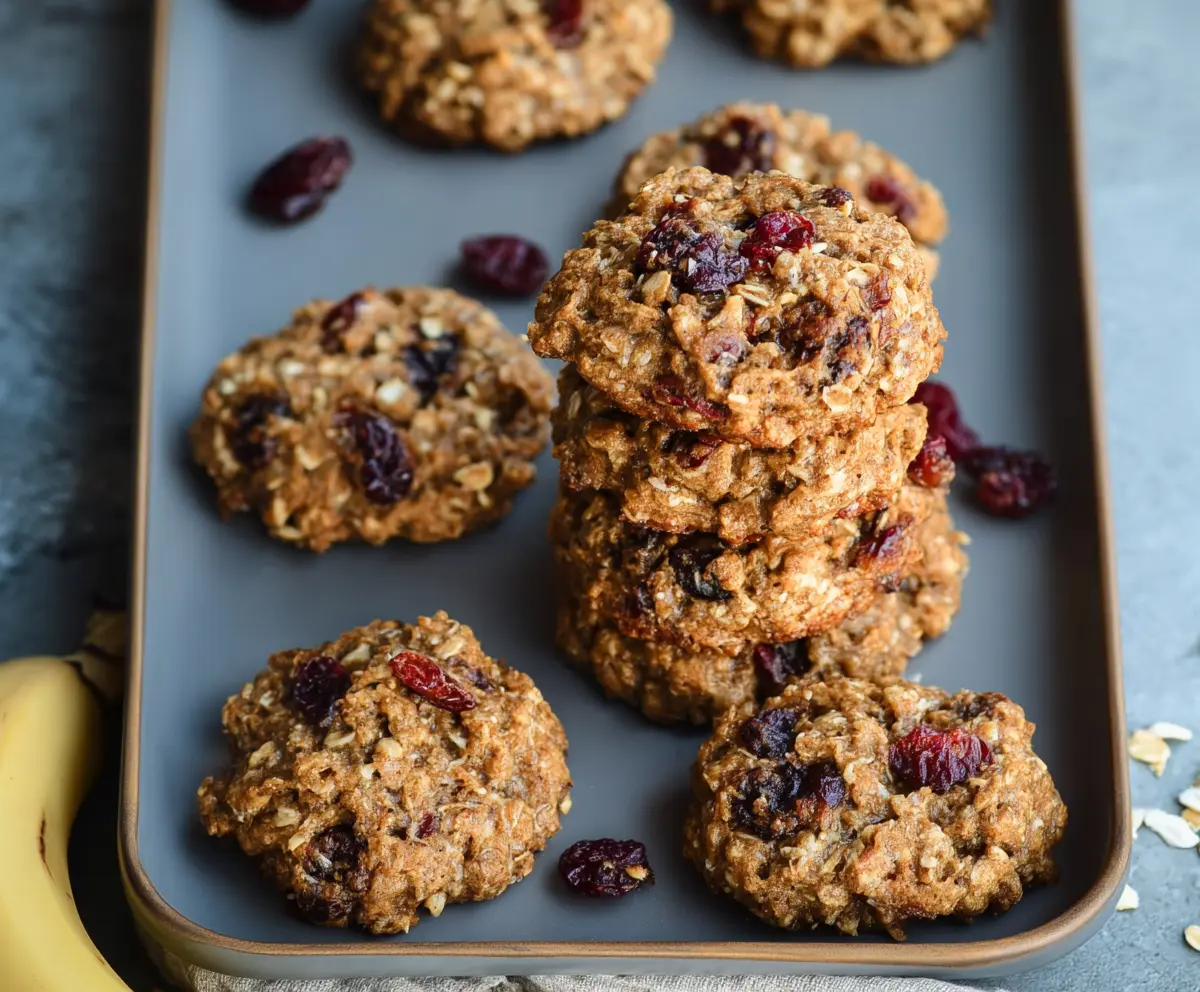 Healthy oatmeal breakfast cookies with oats, bananas, and walnuts on a white plate.
