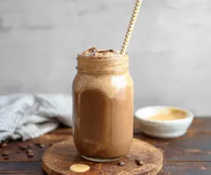 Refreshing Iced Coffee Protein Shake in a clear glass with ice cubes and a straw, perfect for a quick protein boost.