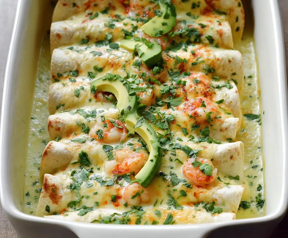 Delicious shrimp enchiladas topped with creamy poblano sauce on a colorful plate