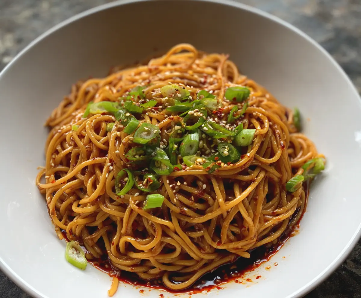 Refreshing Cold Spicy Szechuan Sesame Noodles garnished with chopped green onions and sesame seeds.