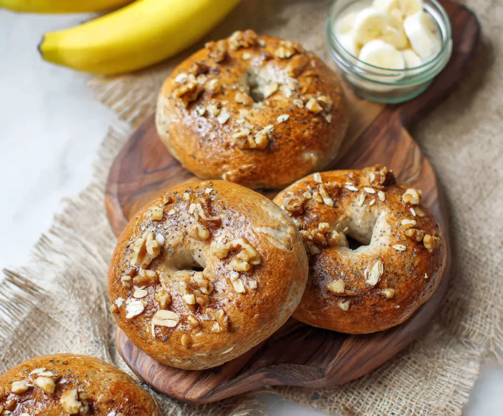 Delicious homemade banana nut bagels topped with sliced bananas and chopped nuts, perfect for breakfast or a snack.