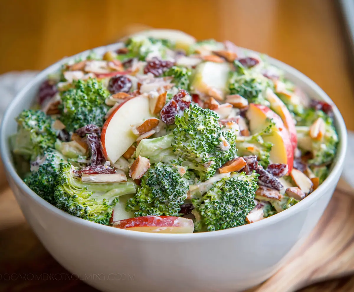 Fresh broccoli and crisp apple salad in a bowl, healthy and colorful recipe image.