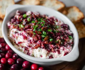 Creamy cranberry jalapeno cream cheese dip garnished with fresh herbs, perfect for appetizers.