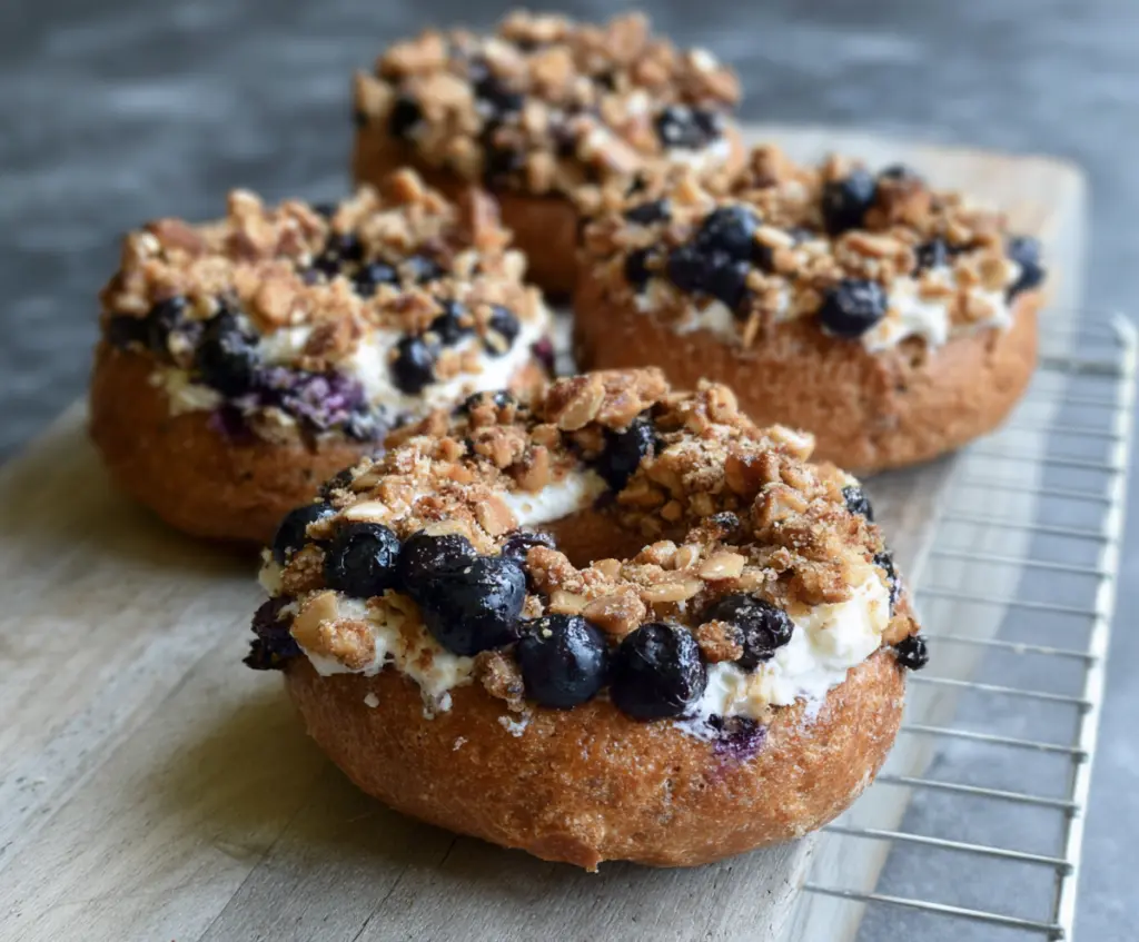 Delicious Greek Yogurt Blueberry Crunch Bagels with fresh blueberries and a crunchy topping.