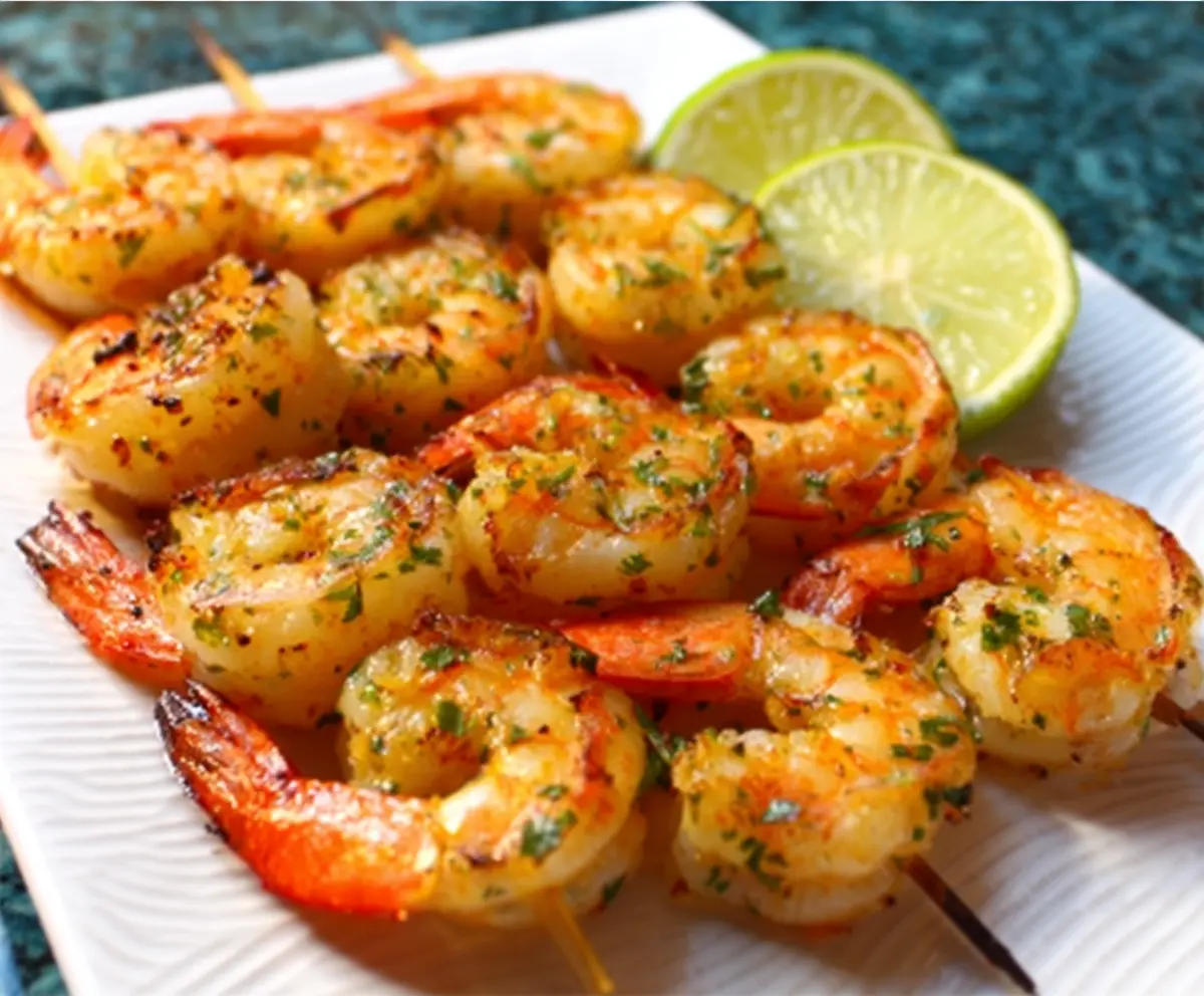Juicy grilled garlic lime shrimp served on a plate with fresh herbs
