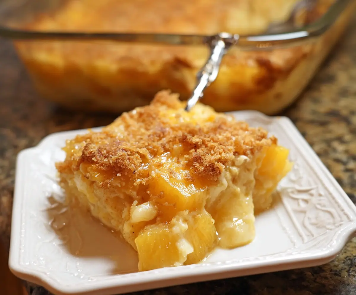 Delicious pineapple cheese casserole served in a baking dish, topped with melted cheese and pineapple chunks.